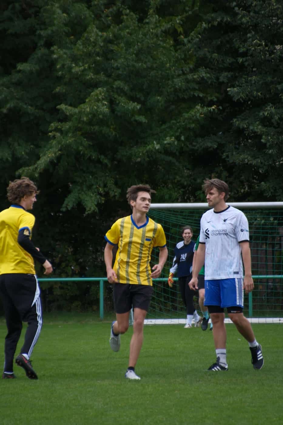 Drei Spieler laufen auf das Tor zu